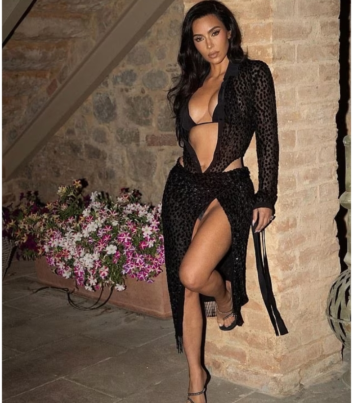 Kim Kardashian turns up the heat in a skimpy black bikini and teases about joining Love Island: 'A bombshell just entered the villa'