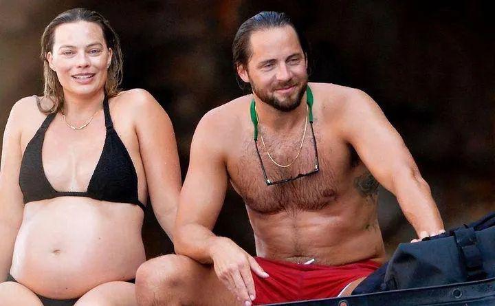 Pregnant Margot Robbie couldn’t take the smile off her face as she showcases her growing baby bump in a black bikini while relaxing with husband Tom Ackerley during sun-soaked break to Italy